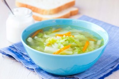 Vegetable soup with cabbage, kohlrabi, carrots, healthy vegetarian diet dish with sour cream and bread